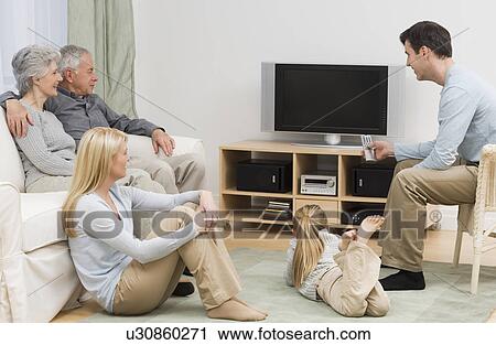 Stock Image - Multi-generational family watching television. Fotosearch