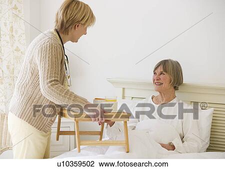 Nurse bringing senior woman breakfast in bed View Large Photo Image Stock Image - Nurse bringing senior woman breakfast in bed. Fotosearch