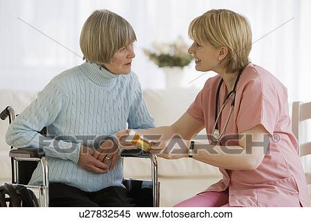 Stock Photography - Nurse discussing medication with senior woman. Fotosearch