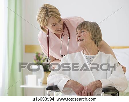 Picture - Nurse pushing senior woman in wheelchair. Fotosearch