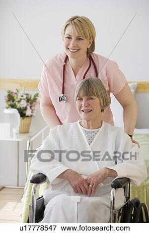 Nurse pushing senior woman in wheelchair View Large Photo Image Stock Photo - Nurse pushing senior woman in wheelchair. Fotosearch