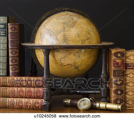 Stock Photo - Old fashioned globe and books on table. Fotosearch