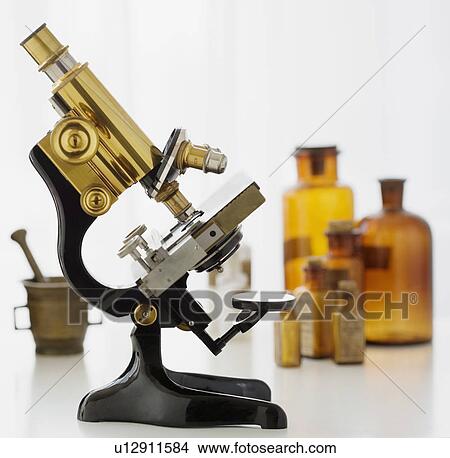 Picture - Old fashioned microscope and bottles. Fotosearch