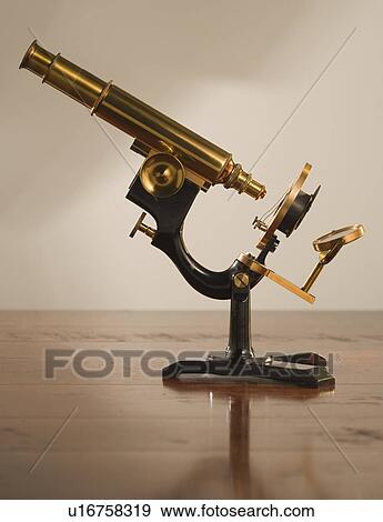 Stock Photo - Old fashioned microscope on table. Fotosearch