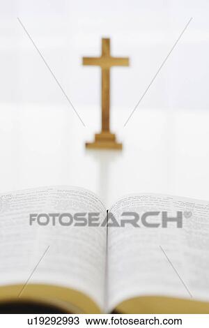 Stock Image - Open book and cross in background. Fotosearch
