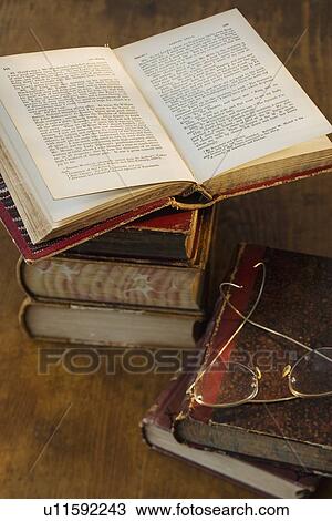 Stock Image - Open book next to eyeglasses. Fotosearch