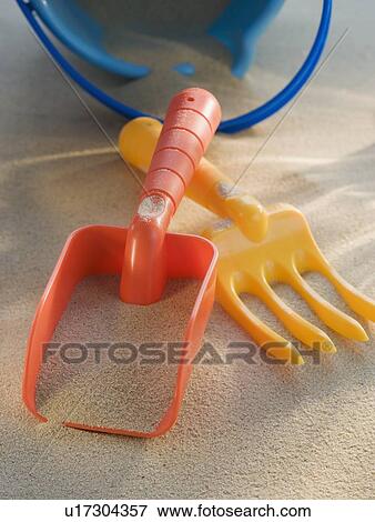 Stock Photo - Pail and shovel toys in sand. Fotosearch
