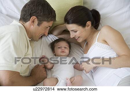 Picture - Parents smiling at baby. Fotosearch