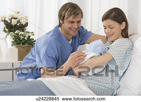 Parents smiling at newborn baby in hospital View Large Photo Image Stock Photography - Parents smiling at newborn baby in hospital. Fotosearch