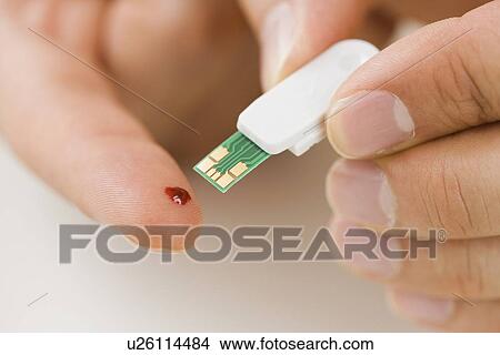 Person using blood sugar monitor on finger View Large Photo Image Picture - Person using blood sugar monitor on finger. Fotosearch