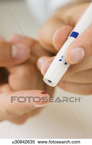 Person using blood sugar monitor on finger View Large Photo Image Stock Photography - Person using blood sugar monitor on finger. Fotosearch