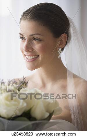Stock Photo - Portrait of bride holding bouquet. Fotosearch