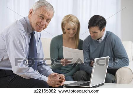 Portrait of businessman with couple in background View Large Photo Image Stock Image - Portrait of businessman with couple in background. Fotosearch