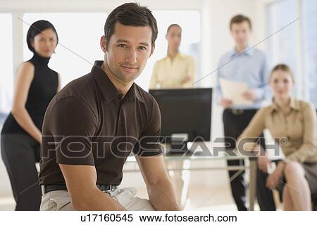 Stock Photography - Portrait of businessman with coworkers in background. Fotosearch