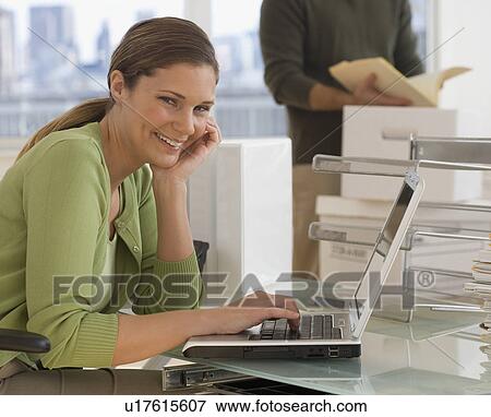 Stock Photo - Portrait of businesswoman typing on laptop. Fotosearch