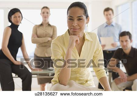 Portrait of businesswoman with coworkers in background View Large Photo Image Stock Photo - Portrait of businesswoman with coworkers in background. Fotosearch