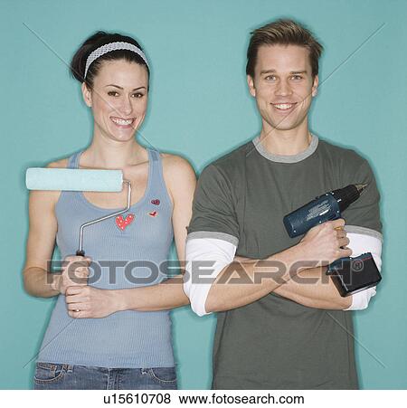 Portrait of couple holding paint roller and cordless drill View Large Photo Image Stock Photo - Portrait of couple holding paint roller and cordless drill. Fotosearch