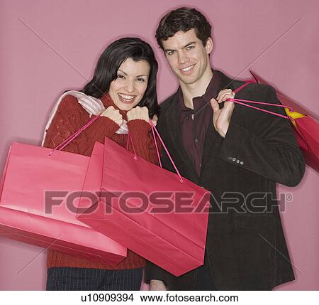 Portrait of couple holding shopping bags View Large Photo Image Picture - Portrait of couple holding shopping bags. Fotosearch