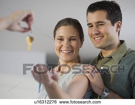 Stock Photograph - Portrait of couple receiving keys. Fotosearch