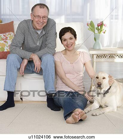 Portrait of couple with dog in livingroom View Large Photo Image Stock Photograph - Portrait of couple with dog in livingroom. Fotosearch