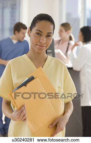 Portrait of female doctor holding files View Large Photo Image Stock Image - Portrait of female doctor holding files. Fotosearch