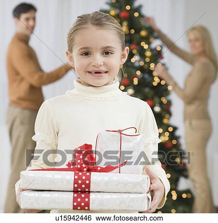 Portrait of girl holding gifts on Christmas View Large Photo Image Stock Photograph - Portrait of girl holding gifts on Christmas. Fotosearch