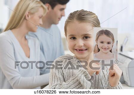 Portrait of girl holding picture of self View Large Photo Image Stock Photograph - Portrait of girl holding picture of self. Fotosearch
