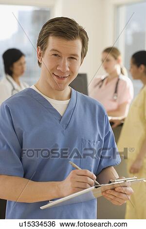 Portrait of male doctor writing on chart View Large Photo Image Stock Photograph - Portrait of male doctor writing on chart. Fotosearch