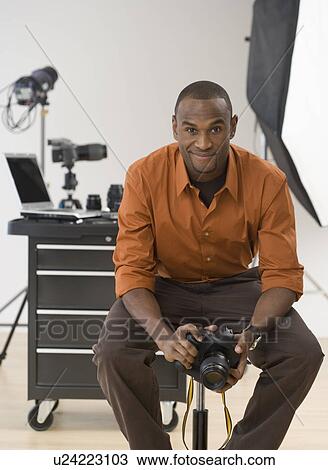 Stock Image - Portrait of male photographer in studio. Fotosearch