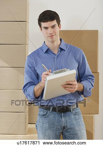Portrait of man holding clipboard View Large Photo Image Stock Image - Portrait of man holding clipboard. Fotosearch