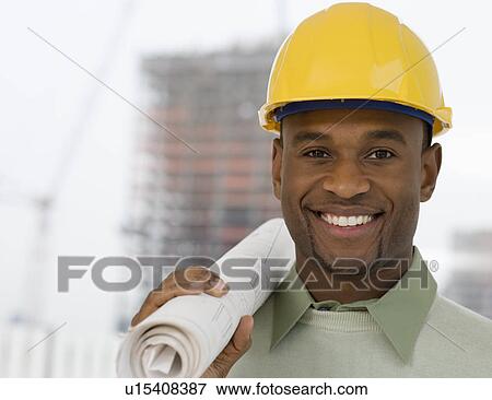 Stock Photo - Portrait of man in hard hat holding blueprints. Fotosearch