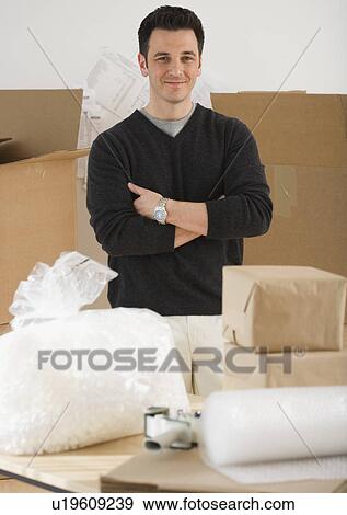 Portrait of man next to packing supplies View Large Photo Image Stock Photo - Portrait of man next to packing supplies. Fotosearch