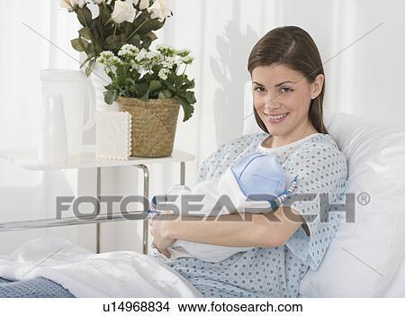 Portrait of mother holding newborn baby in hospital View Large Photo Image Picture - Portrait of mother holding newborn baby in hospital. Fotosearch