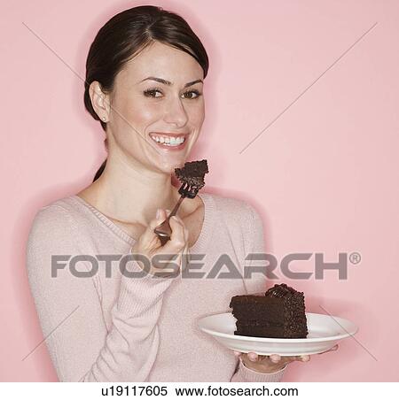 Stock Photography - Portrait of woman eating cake. Fotosearch