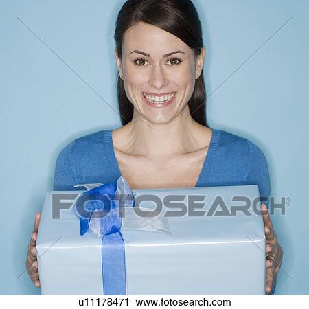 Stock Image - Portrait of woman holding gift. Fotosearch