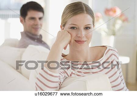 Stock Photo - Portrait of woman on sofa. Fotosearch
