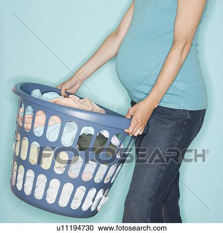Pregnant woman carrying laundry basket View Large Photo Image Stock Image - Pregnant woman carrying laundry basket. Fotosearch