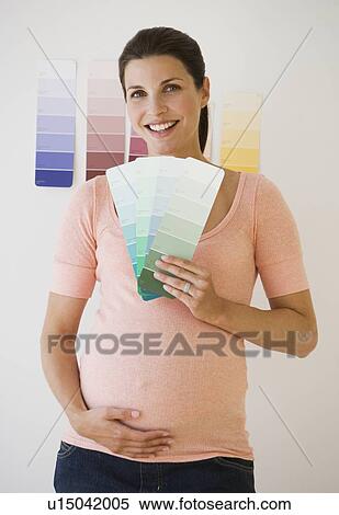 Pregnant woman looking at paint swatches View Large Photo Image Stock Photography - Pregnant woman looking at paint swatches. Fotosearch