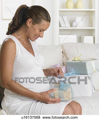Pregnant woman on sofa opening gifts View Large Photo Image Stock Photo - Pregnant woman on sofa opening gifts. Fotosearch