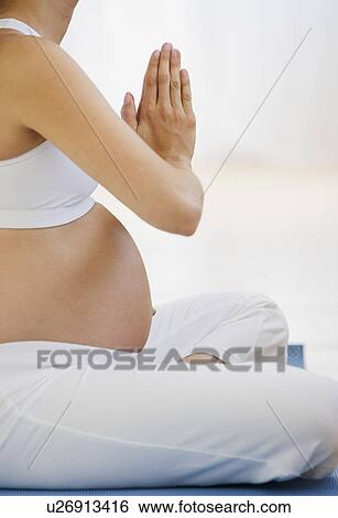 Stock Photograph - Pregnant woman practicing yoga. Fotosearch
