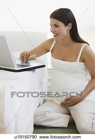 Stock Image - Pregnant woman shopping online. Fotosearch