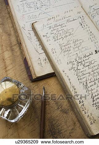 Stock Photo - Quill pen and ink jar next to old ledger books. Fotosearch