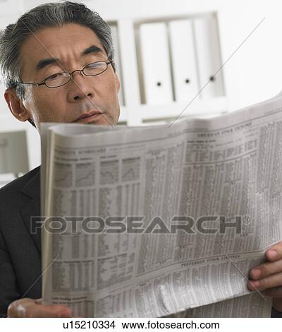 Picture - Senior Asian businessman reading newspaper. Fotosearch