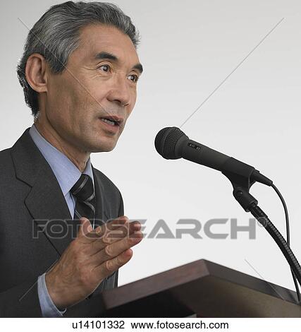 Senior Asian businessman speaking at podium View Large Photo Image Stock Image - Senior Asian businessman speaking at podium. Fotosearch