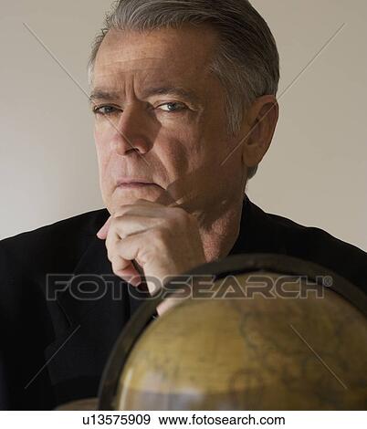 Stock Photo - Senior businessman next to globe. Fotosearch