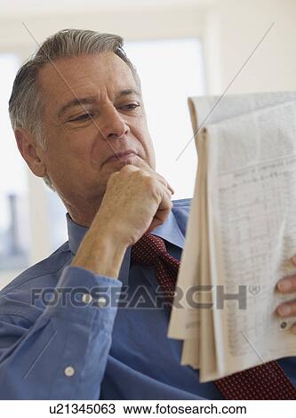 Stock Image - Senior businessman reading newspaper. Fotosearch