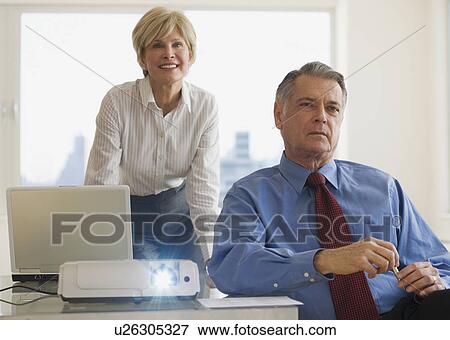 Senior businesspeople using projector in conference room View Large Photo Image Stock Photo - Senior businesspeople using projector in conference room. Fotosearch