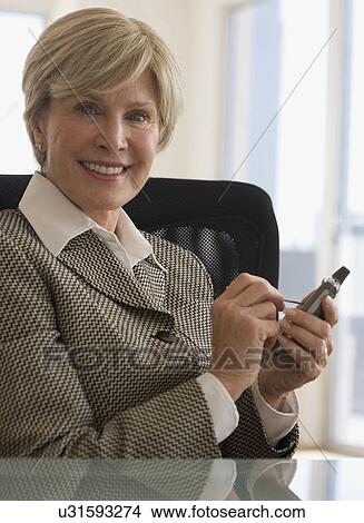 Senior businesswoman holding electronic organizer View Large Photo Image Picture - Senior businesswoman holding electronic organizer. Fotosearch
