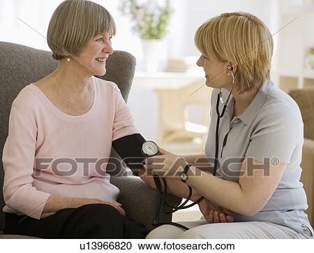 Stock Image - Senior woman having blood pressure taken. Fotosearch