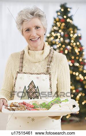 Senior woman holding tray of Christmas cookies View Large Photo Image Stock Image - Senior woman holding tray of Christmas cookies. Fotosearch